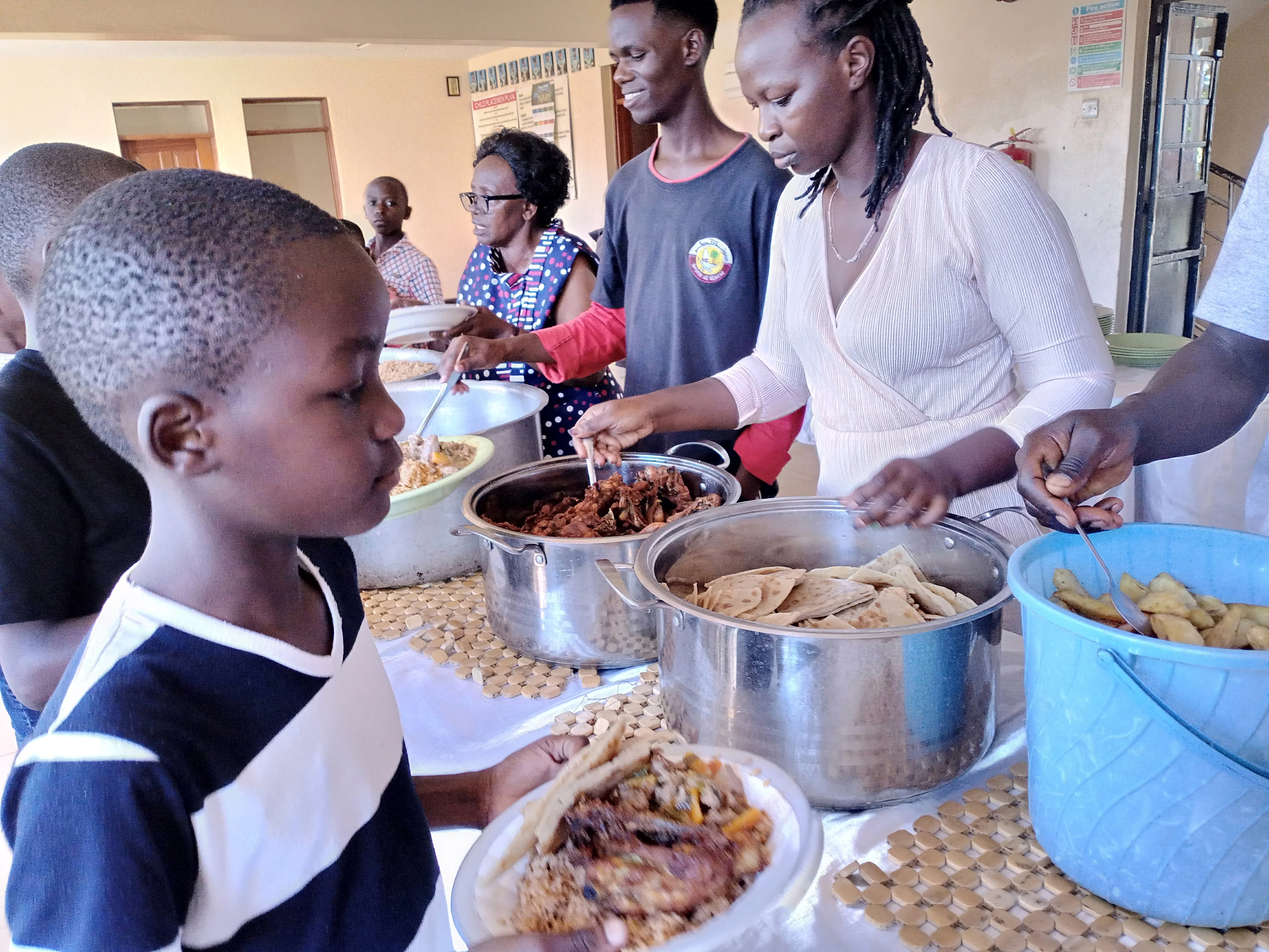 Children and visitors sharing a meal